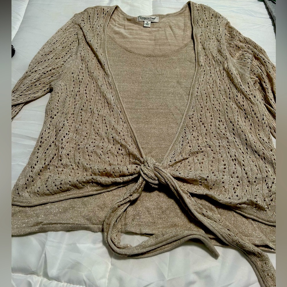 Lightweight gold sweater with metallic threads.  Open weave arms and tie front.